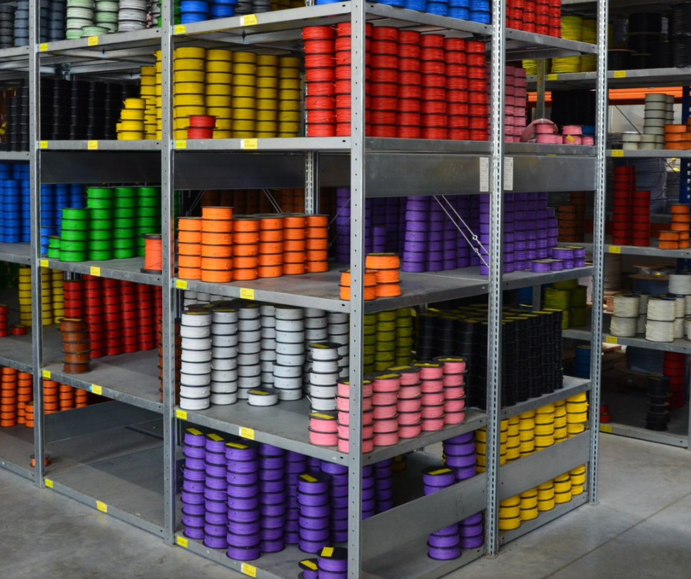 Kuva hyllystä, jossa on paljon erivärisiä kaapeleita